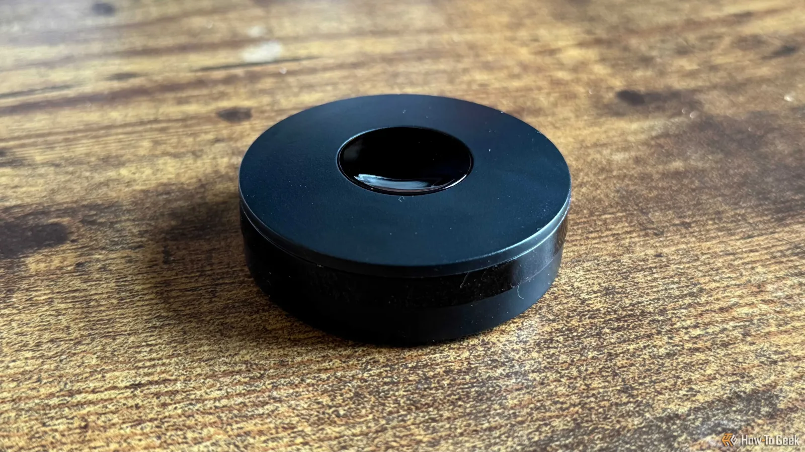 A black IR blaster on a desk.