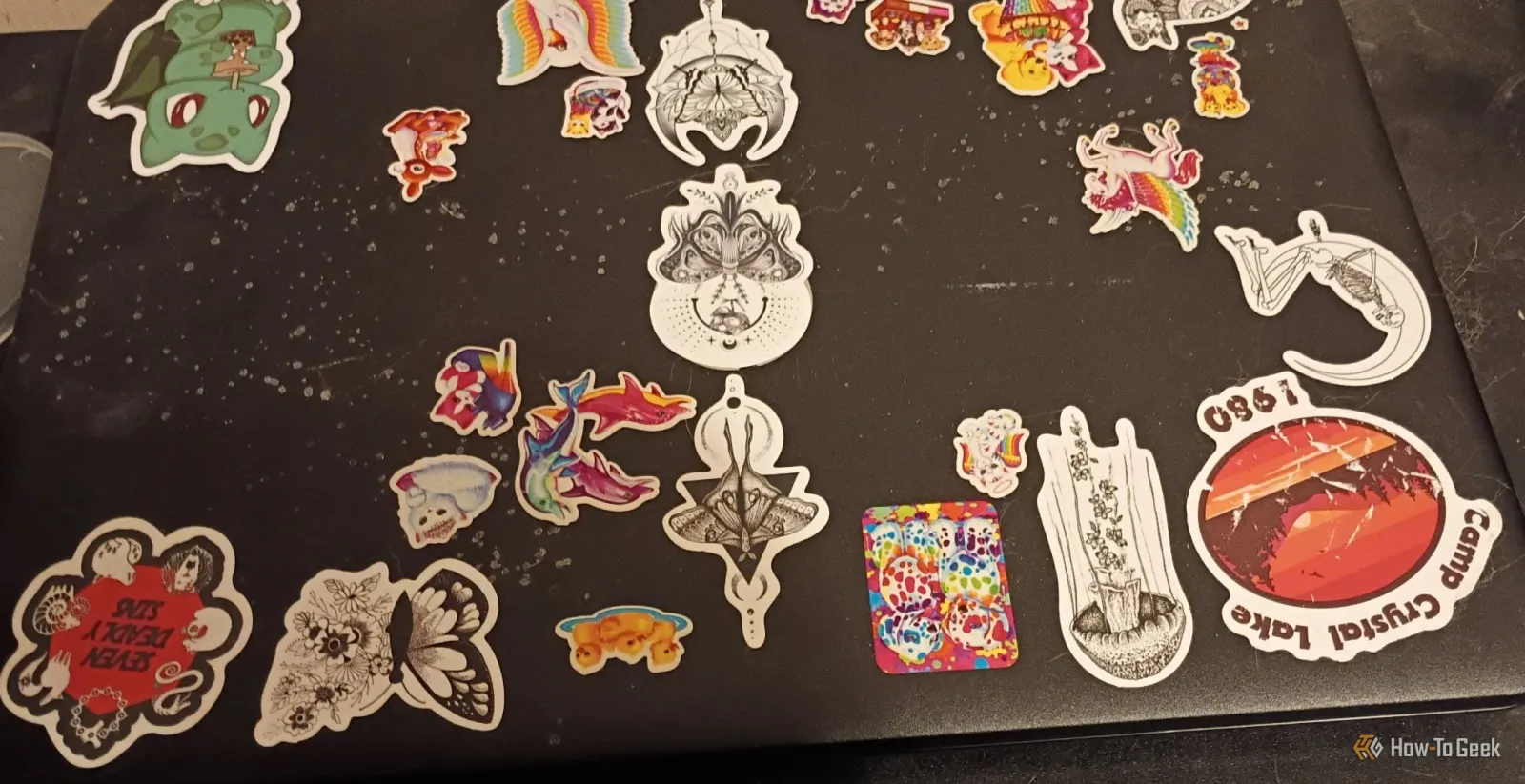Crni laptop sa naljepnicama pop kulture.